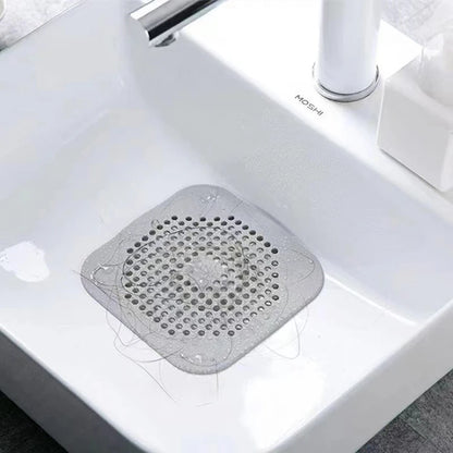 Gray drain cover on a white sink