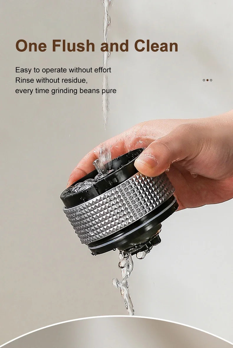 Hand using a coffee grinder with water being poured over it, on a neutral background.