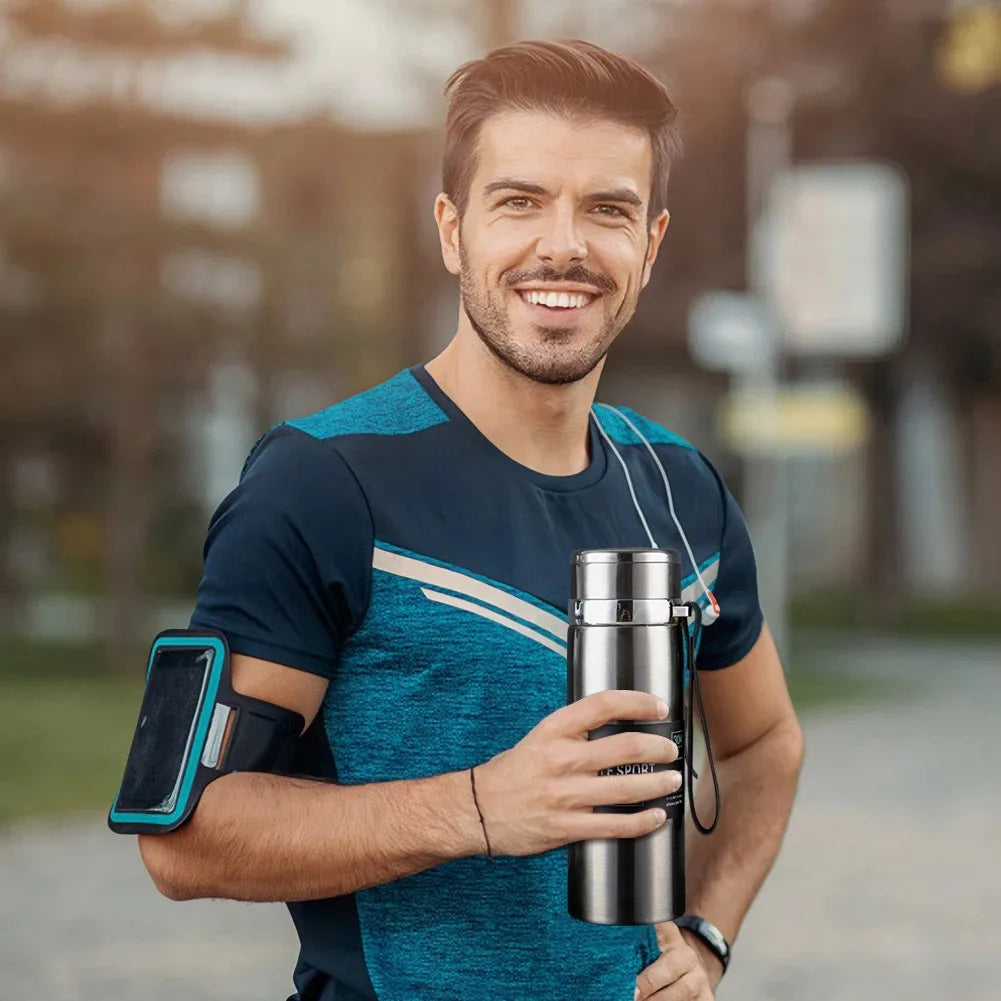 Man in athletic wear holding a water bottle and phone case outdoors