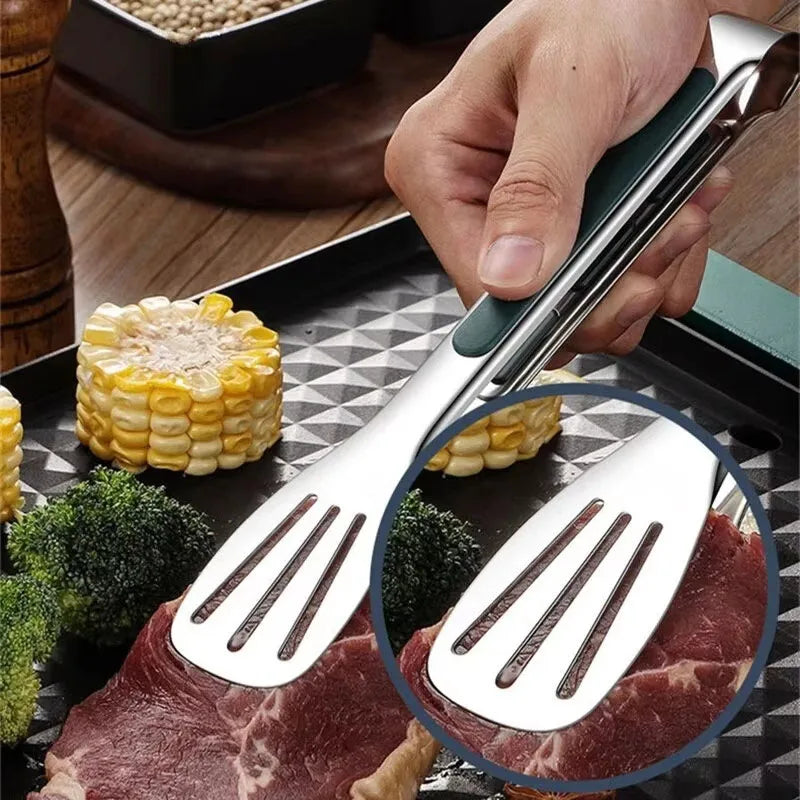 Metallic spatula being used on a grill with close-up of the blade, surrounded by corn and broccoli.