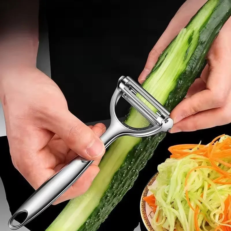 Person using a vegetable peeler to slice a cucumber with a bowl of sliced vegetables in the background.