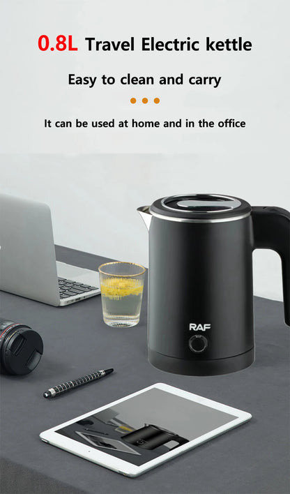 Black travel electric kettle on a desk with a laptop, glass of juice, and tablet.