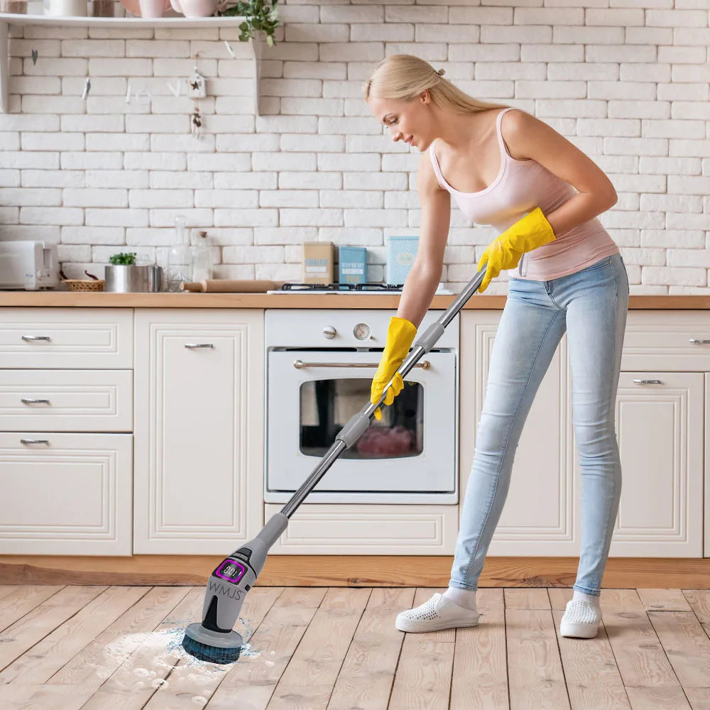 Woman cleaning a kitchen floor with a power scrubber.