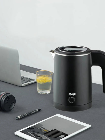 Black electric kettle with 'RAF' branding on a desk with laptop, tablet, and glass.